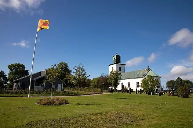En kyrka med en flagga som vajar i luften.